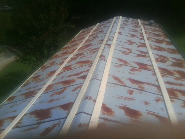 Rusted metal roof panels with new wood purlins before replacement — Storm Damage Roof Repair in Nordman by Roofing Brothers