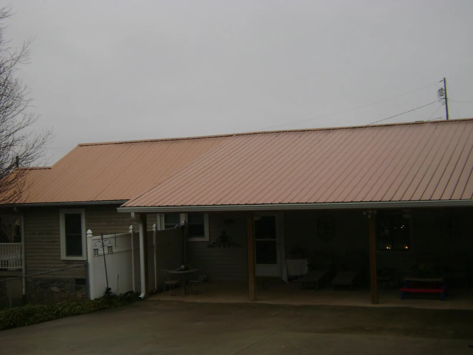Copper toned metal roof over a wide covered patio in Nordman